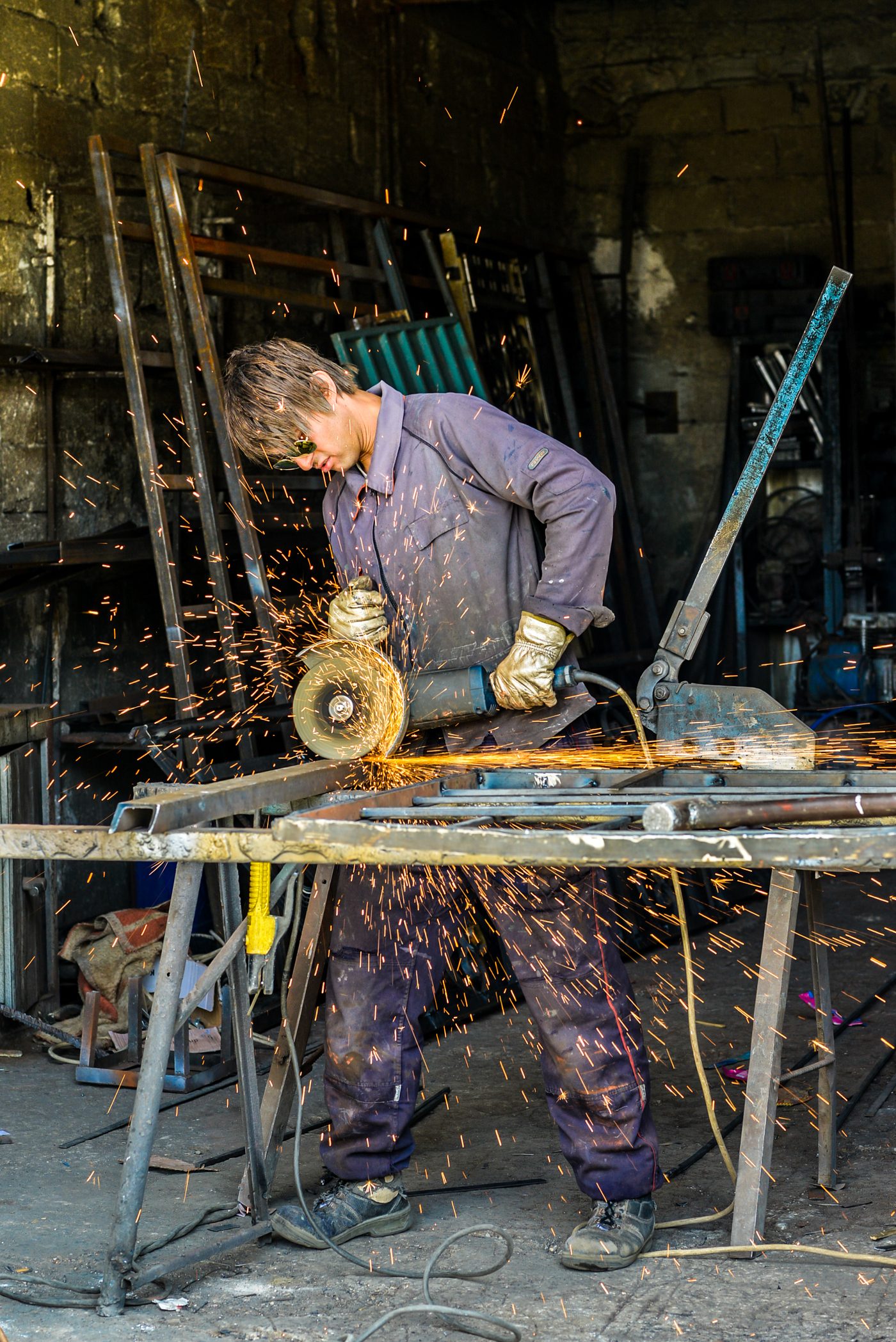 Worker using an angle grinder with sparks