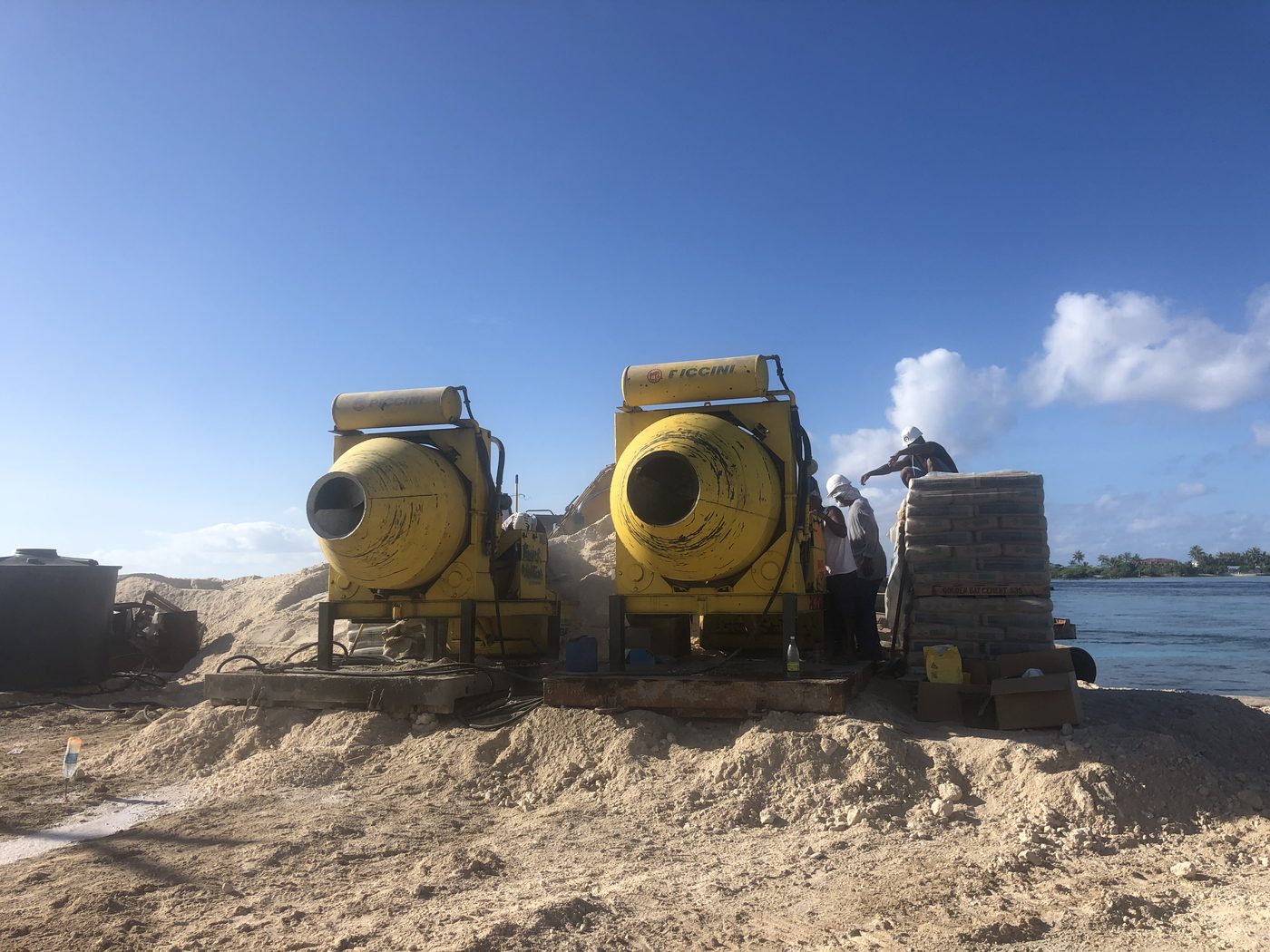 Two yellow concrete mixers on a construction site