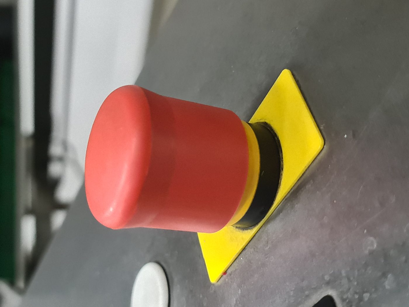 Red emergency stop button on machine panel