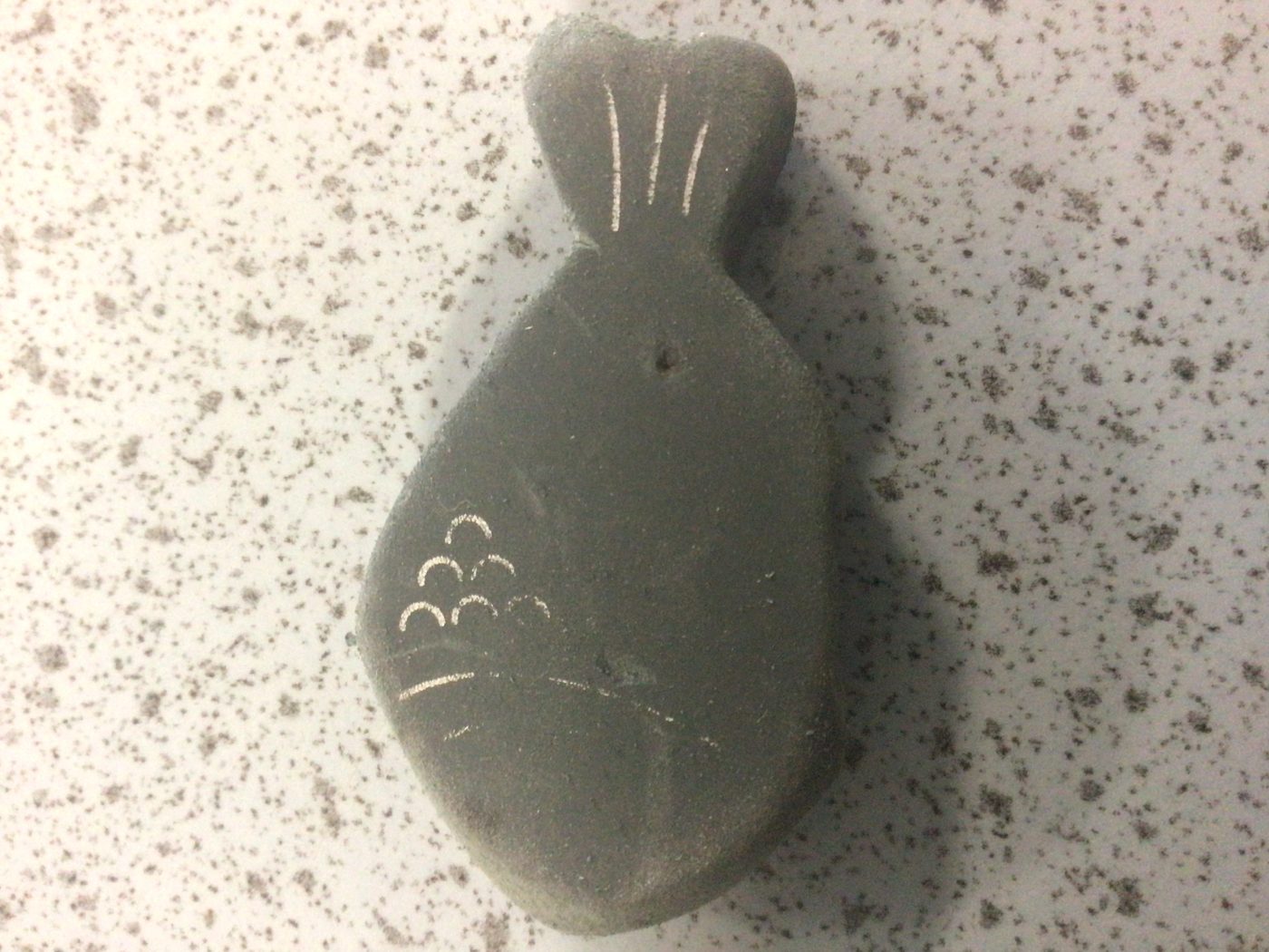 Fish-shaped eraser on speckled surface