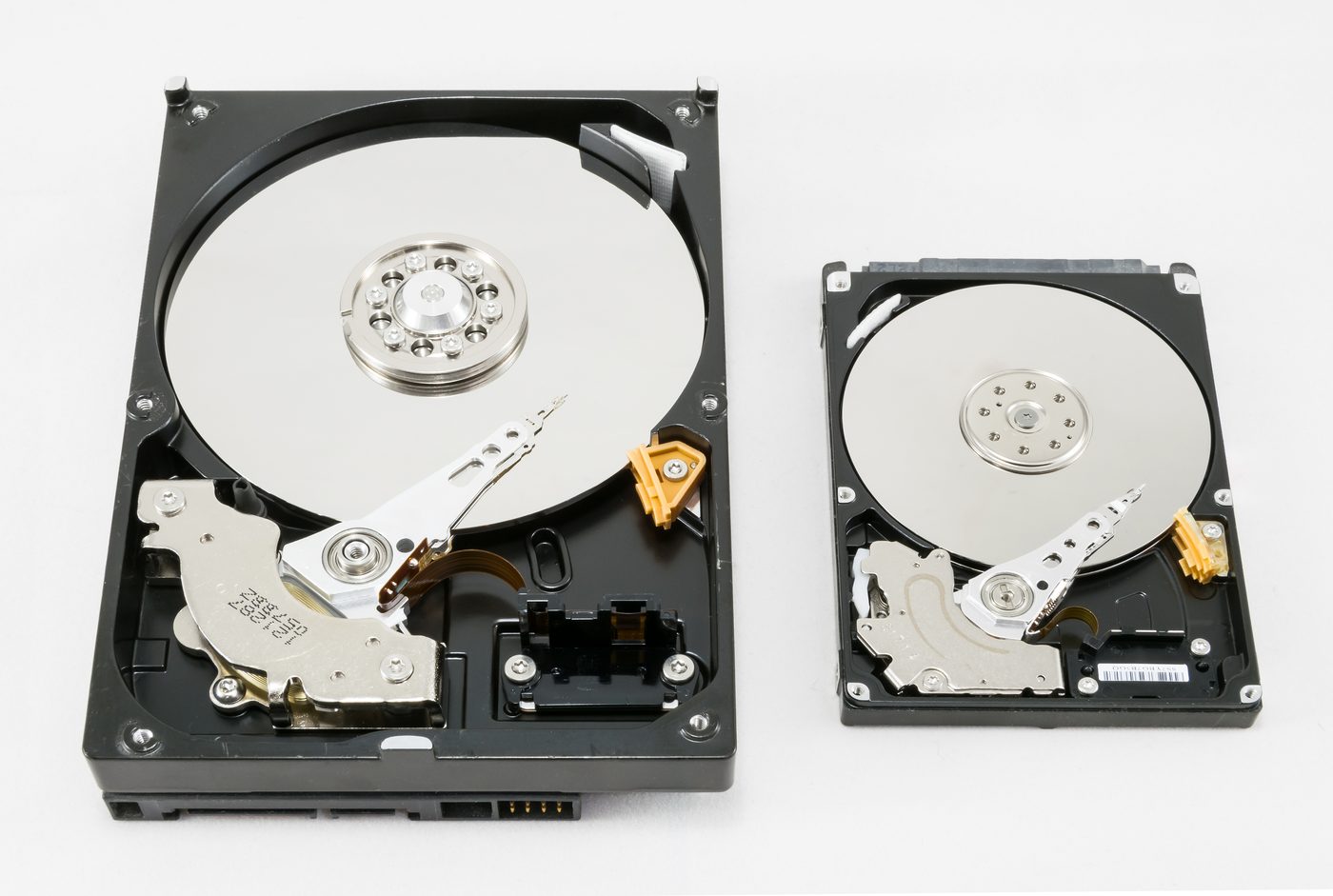 Two opened hard disk drives showing magnetic platters
