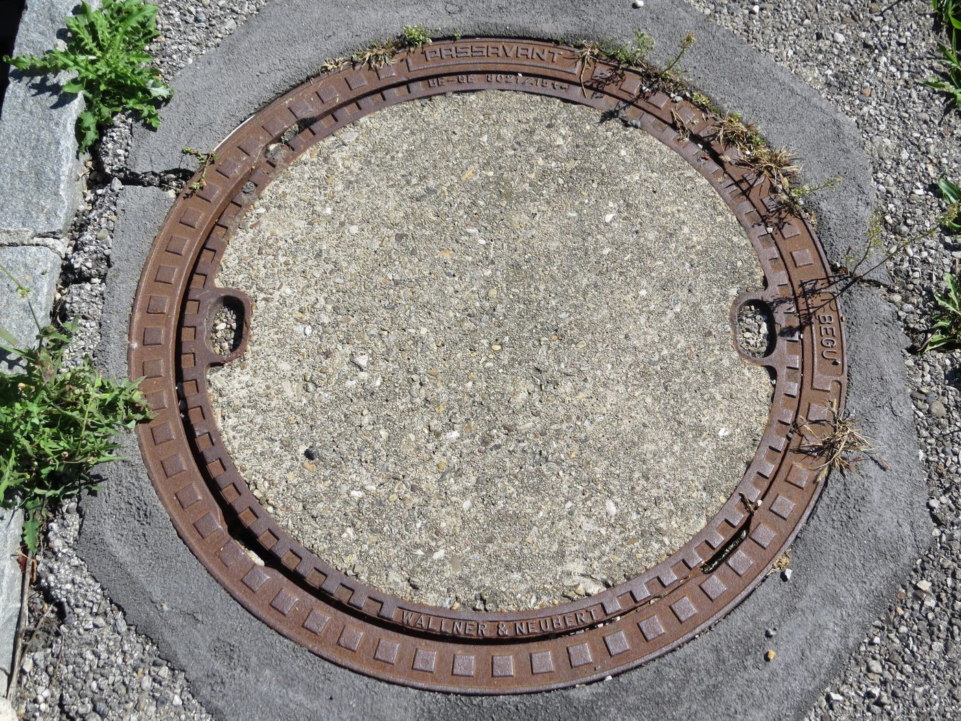 A manhole cover on a concrete surface