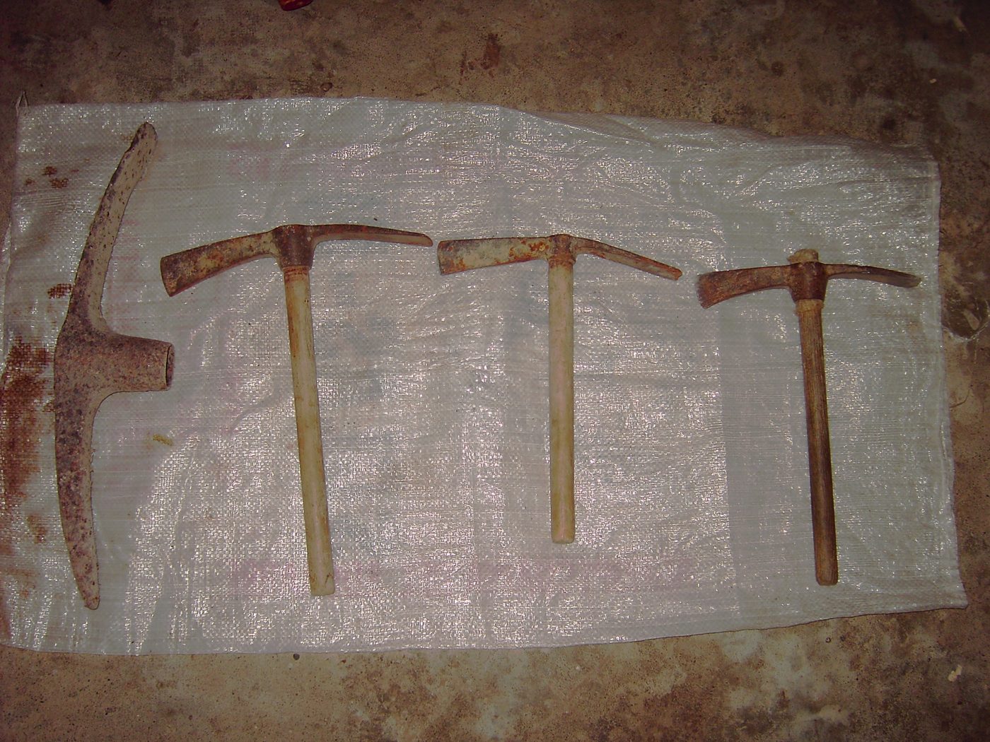 Four mattocks laid on a white sheet