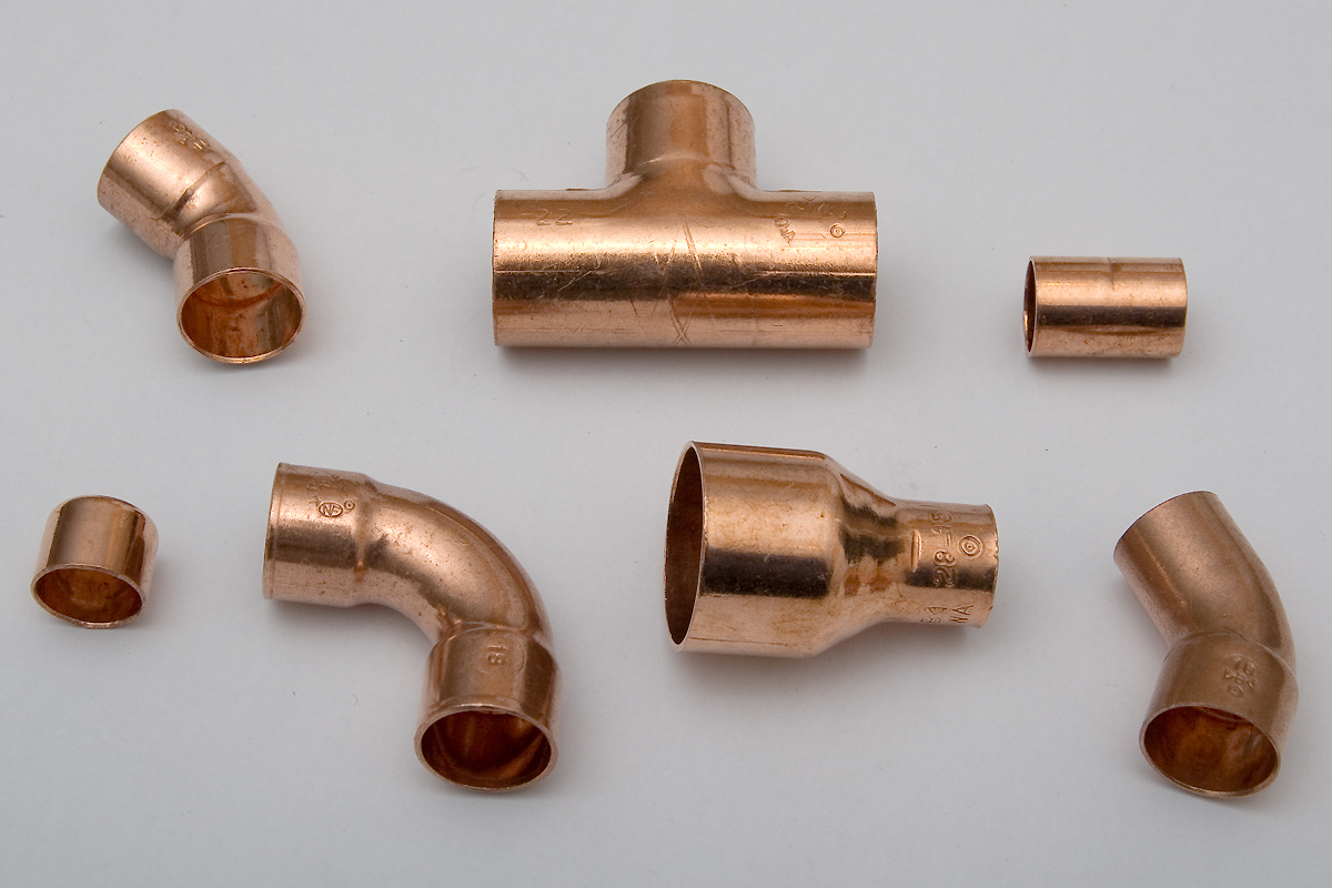 Copper tee fitting among other plumbing fittings