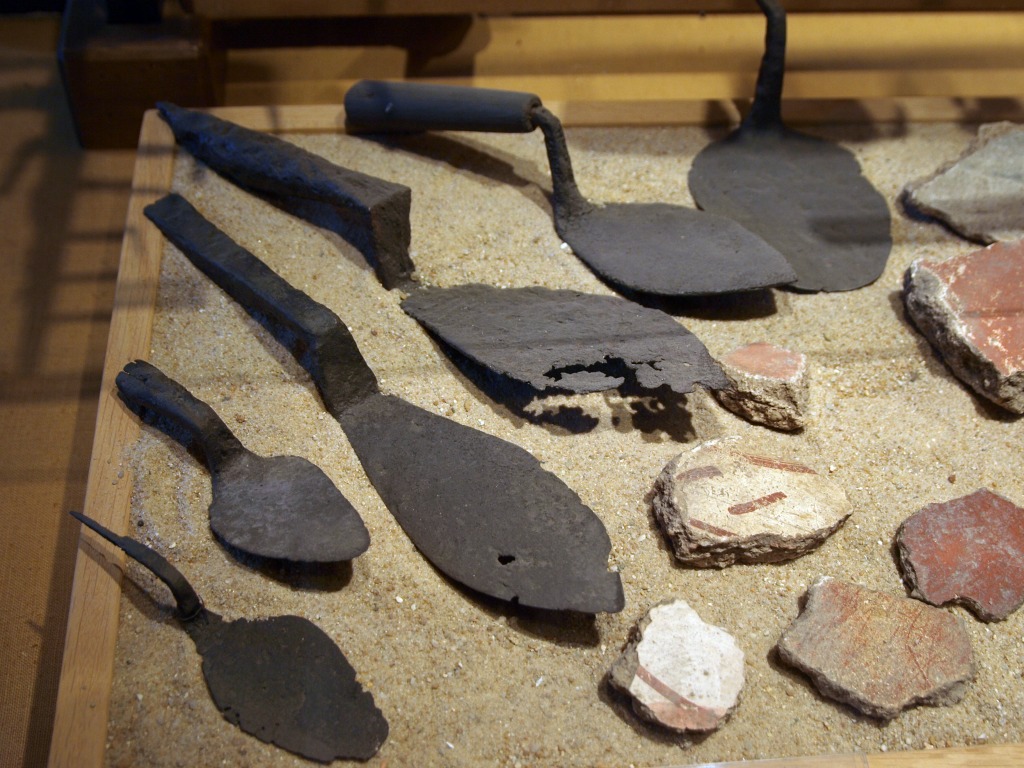 Several trowels displayed on sand